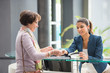 © onoky - Woman making payment with credit card at reception desk