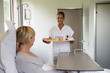 © onoky - Female nurse serving food to patient on hospital bed