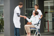 © onoky - Male doctor shaking hands with a female patient sitting in a chair
