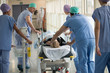 © onoky - Medical professionals pushing patient on gurney in a hospital