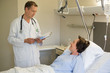 © onoky - Male doctor talking with patient on hospital bed