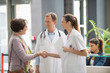 © onoky - Doctor shaking hands with his patient at hospital reception desk