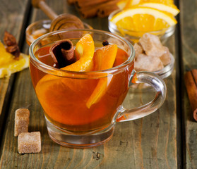 Wall Mural - Christmas tea with orange, honey and spices on a  wooden table