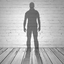 Shadow Of A Man On White Brick Wall And Wooden Floor