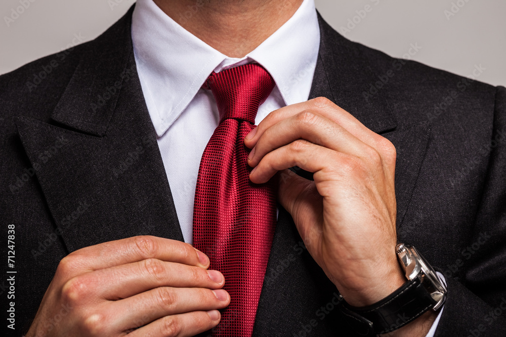 Businessman adjusting his necktie - obrazy, fototapety, plakaty 