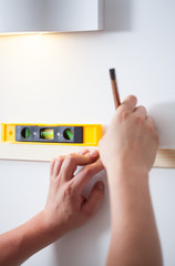 Wall Mural - Handyman's hands with spirit level