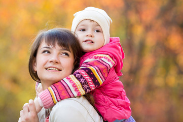 happy family - young mother and kid girl together outdoors in fa