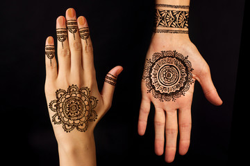hand with mehendi on black background
