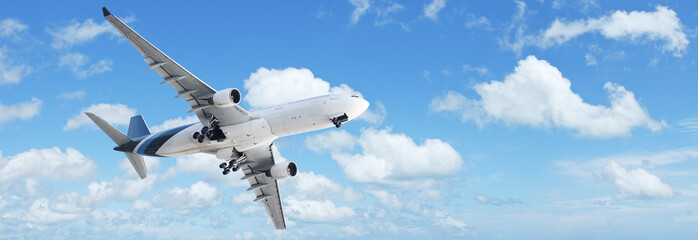 Fototapete - Jet in a blue cloudy sky