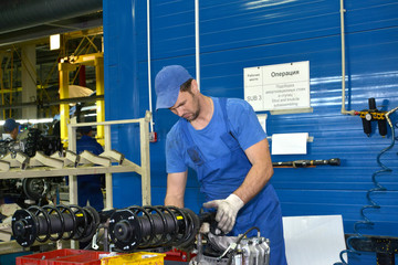 Wall Mural - The worker selects depreciation racks for cars. Assembly shop of