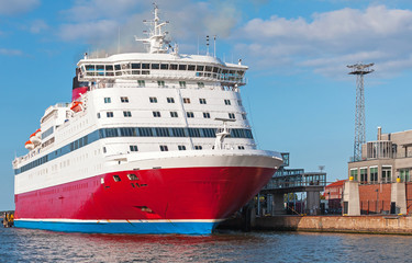 Red and white passenger ferry is moored in port