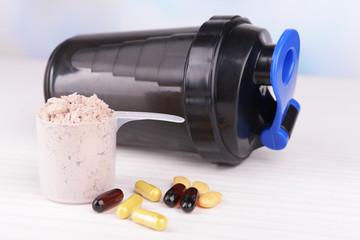 Poster - Whey protein powder in scoop with vitamins and plastic shaker