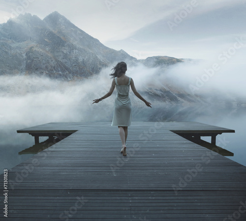 Naklejka na drzwi Alluring woman walking on the wooden pier