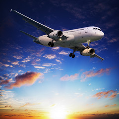 Fototapete - Jet plane in a sunset sky