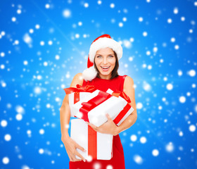 Wall Mural - smiling woman in red dress with gift boxes