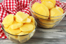 Raw Peeled And Sliced Potatoes In Glass Bowls
