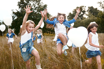 Sticker - portrait of a little girls in a field with white balloons