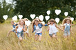 © zagorodnaya - portrait of a little girls in a field with white balloons