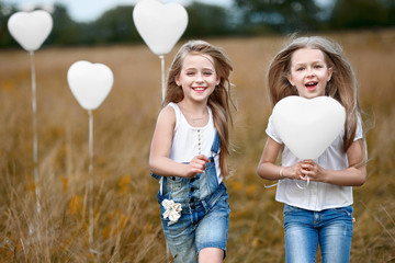 portrait of a little girls in a field with white balloons