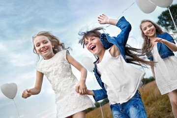 Sticker - portrait of a little girls in a field with white balloons