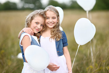 Sticker - portrait of a little girls in a field with white balloons