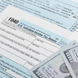 © niyazz - US Tax Form 1040 with 100 dollars bills - 1 to 1 ratio