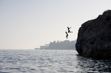 People Jumping Into The Water From Cliff