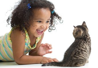 Happy kid girl lying on floor and playing with kitten isolated