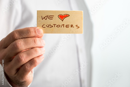 Fotografía Hand Holding Small We Love Customer Signage