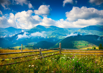 Wall Mural - amazing mountain landscape with fog and a haystack