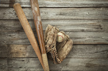 Old Baseball With Mitt And Bats On Rough Wood