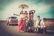 © Nejron Photo - Multi-ethnic hippie hitchhikers with guitar and luggage