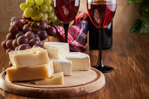 Photo Cheese with a bottle and glasses of red wine
