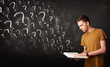 © ra2 studio - Young man reading a book with question marks coming out from it