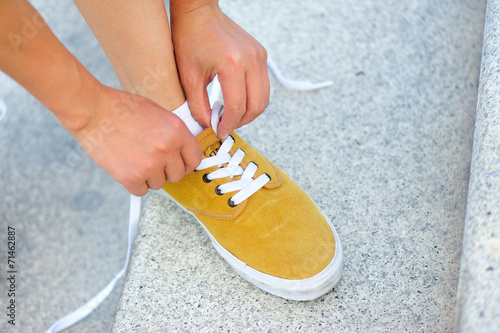 Cuadros en Lienzo woman runner tying shoelace on stone stairs