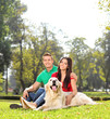 © Ljupco Smokovski - Young couple sitting in park with a dog