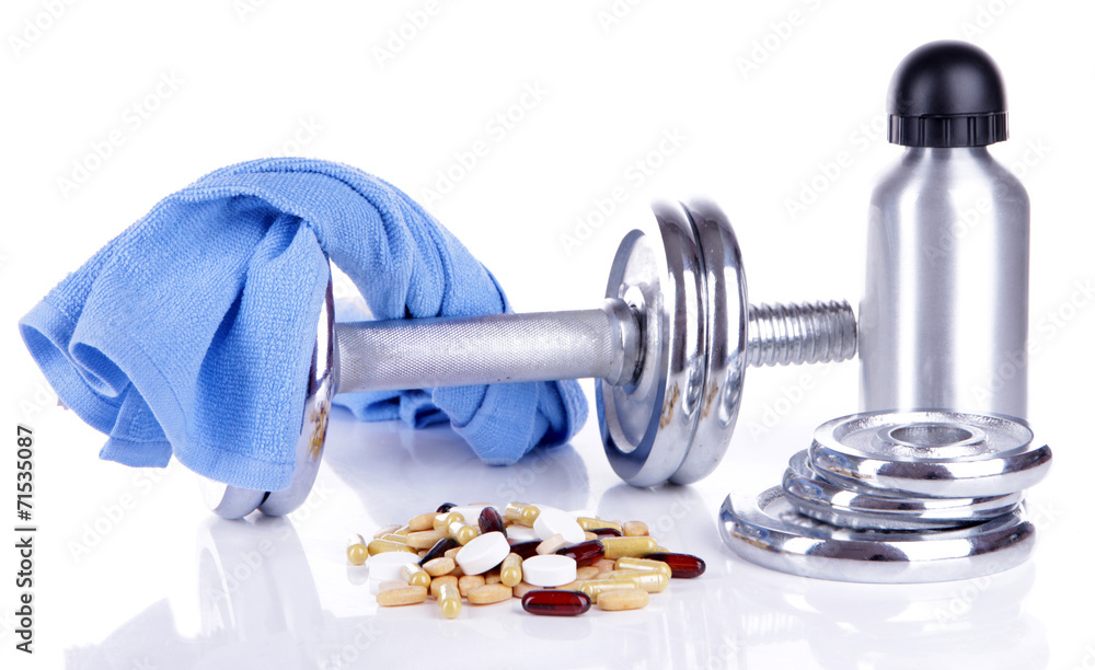 Dumbbell and colorful pills, tablets, isolated on white