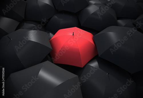 Fényképezés  Red umbrella standing out from background of black umbrellas