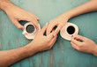 © Africa Studio - Coffee cups and holding hands at the wooden table