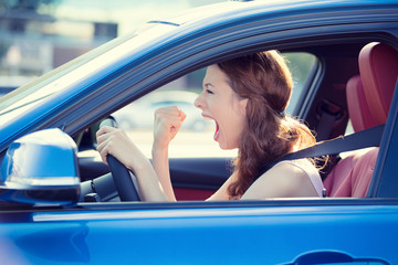 angry aggressive young woman driving car in heavy traffic 