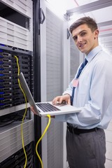 Poster - Portrait of a technician using laptop while analysing server