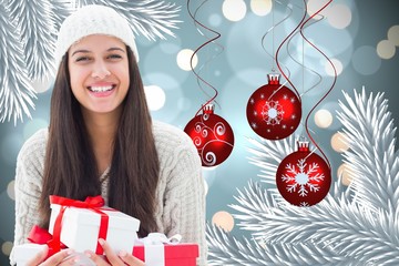 Poster - Composite image of festive brunette holding gifts