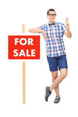 Wall Mural - Man holding an ice cream by a for sale sign