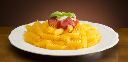 dish with macaroni and tomato sauce on the wooden table