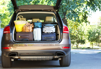 Wall Mural - Suitcases and bags in trunk of car ready to depart for holidays