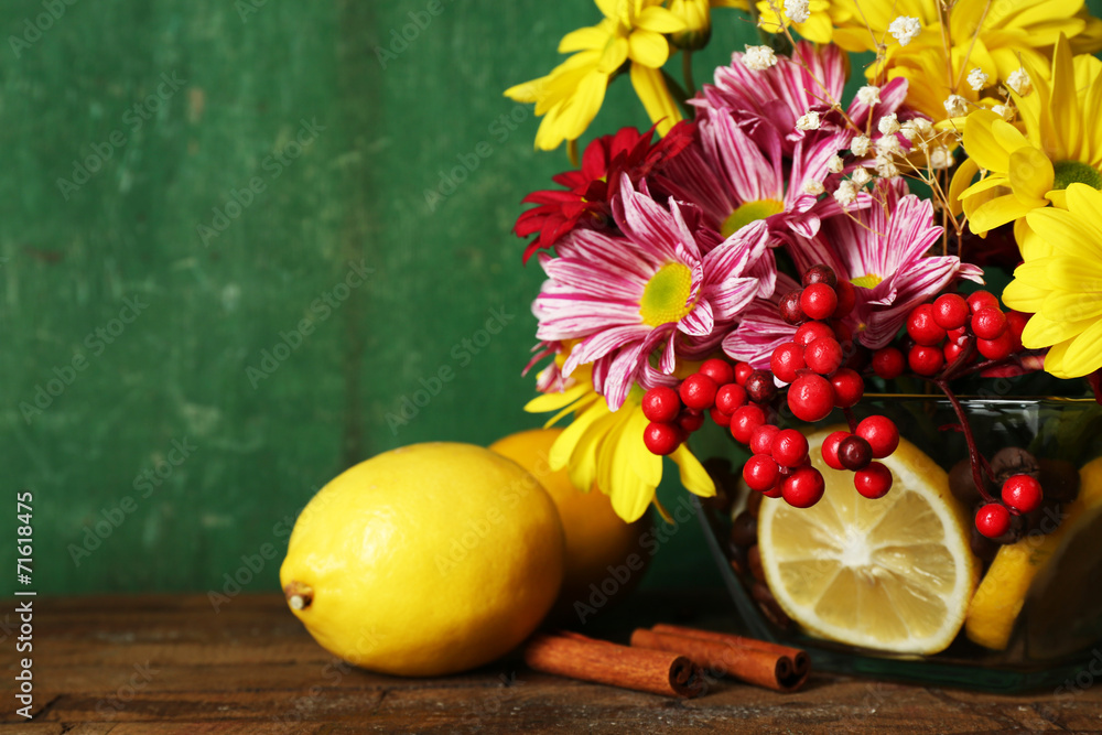 Beautiful chrysanthemum and lemons on wooden background