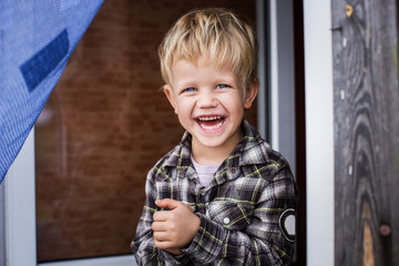 Cute little blond boy laughing. Happiness