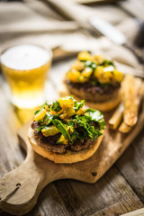 Wall Mural - Homemade burgers with fries on wooden background