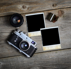 Vintage camera with lenses and blank old photograph on wooden ba