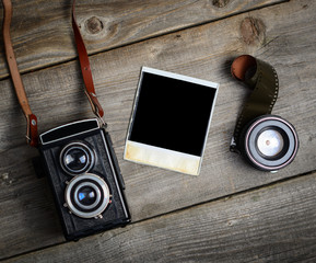 Canvas Print - Vintage camera with lenses and blank old photograph on wooden ba